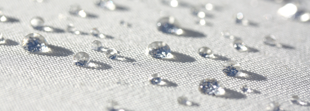 Water droplets beading on fabric treated with C0 DWR durable water repellent finish