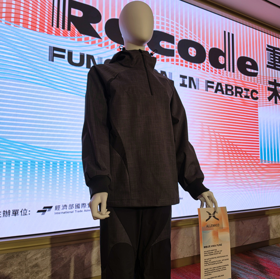 ALLENKO3 dark grey hooded half-zip jacket and paneled pants made with Hwafune PORLITE&reg; fabrics, displayed at the RECODE 2050 fashion show at TITAS